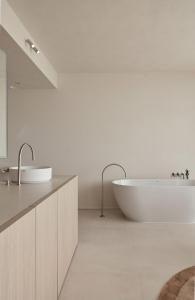 a bathroom with two sinks and a bath tub at Enso District Hotel in Knokke-Heist