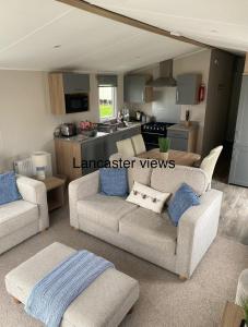 a living room with two couches and a kitchen at Lancaster Views, Luxury 2022 home with Hot Tub in Tattershall