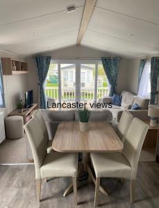 een eetkamer en een woonkamer met een tafel en stoelen bij Lancaster Views, Luxury 2022 home with Hot Tub in Tattershall