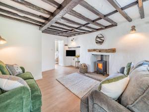 a living room with two couches and a fireplace at Rose Garden Cottage in Heversham
