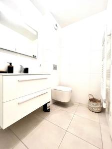 a white bathroom with a sink and a toilet at Appartement Neuf avec Terrasse in Saint-Florent