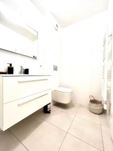 a white bathroom with a sink and a toilet at Appartement Neuf avec Terrasse in Saint-Florent +16 photos