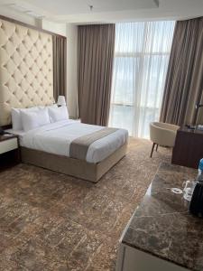 Dolphin Continental Hotel في الكويت: غرفة فندقية بسرير ونافذة كبيرة