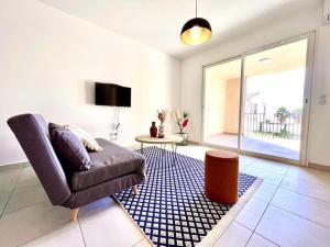 uma sala de estar com um sofá e uma mesa em Appartement Neuf avec Terrasse em Saint-Florent