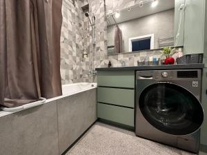 y baño con ducha y lavadora. en Атлант, нижняя Мега, комната для девушек Only for girls, en Almaty