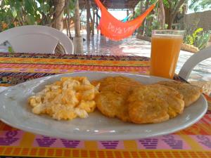 a plate of food on a table with a glass of orange juice at Del Mar Vendra in Manaure Viejo