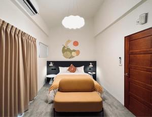 ein Schlafzimmer mit einem großen Bett und einer Holztür in der Unterkunft Hebron Inn in Sanxing Township
