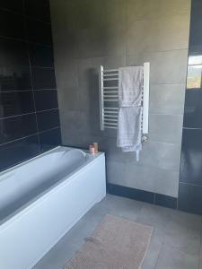 a bathroom with a bath tub and a towel at Lawendowy apartament in Mszana Dolna