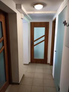 a hallway with a door and a tile floor at Apartament Gosi in Gdynia