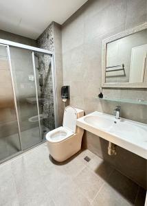 ein Bad mit einem WC, einem Waschbecken und einer Dusche in der Unterkunft Hebron Inn in Sanxing Township