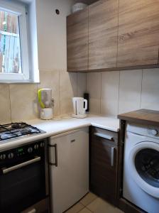 a kitchen with a stove and a washing machine at Apartament Gosi in Gdynia