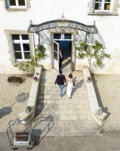 Ein Mann und eine Frau gehen in ein Gebäude in der Unterkunft Chateau Du Boisniard in Chambretaud