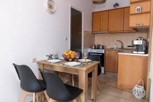 a small kitchen with a wooden table and chairs at Stelios Apartment in Matala