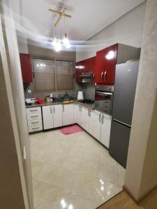 uma cozinha com armários vermelhos e um frigorífico em Location de vacances à la plage de Bouznika em Bouznika
