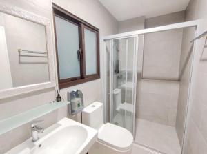 a bathroom with a toilet and a sink and a shower at Hebron Inn in Sanxing