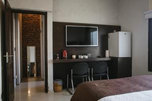 a bedroom with a bar with two chairs and a refrigerator at Tempo Apartamento in Villa Allende