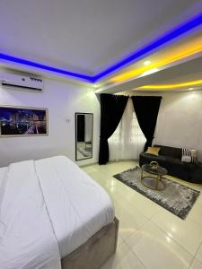 Primal Msquare Apartment Ikoyi في لاغوس: غرفة نوم بسرير ابيض كبير واريكة