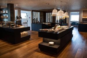 ein Restaurant mit Theken mit ausgestellten Speisen in der Unterkunft Hotel Royal und Ferienhaus Annabel in Sexten
