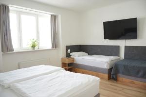 1 Schlafzimmer mit 2 Betten und einem Flachbild-TV in der Unterkunft Chill & Relax Apartments Purbach in Purbach am Neusiedlersee