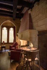 uma sala de estar com uma mesa e uma lareira em Hôtel particulier Fénelon (XIIIe) em Sarlat-la-Canéda