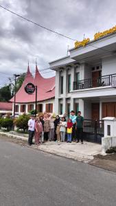 een groep mensen die voor een gebouw staan bij RGA Homestay in Baso