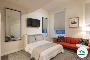 um quarto com uma cama e um sofá vermelho em Inner Harbor's Best Luxury Furnished Apartments apts em Baltimore