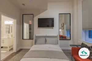 a bedroom with a bed and a tv on the wall at Inner Harbor's Best Luxury Furnished Apartments apts in Baltimore