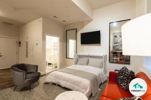 a bedroom with a bed and a chair and a tv at Inner Harbor's Best Luxury Furnished Apartments apts in Baltimore