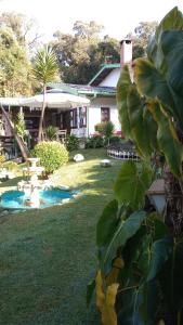 a backyard with a pool and a house at Rancho da Raposa in Campos do Jordão