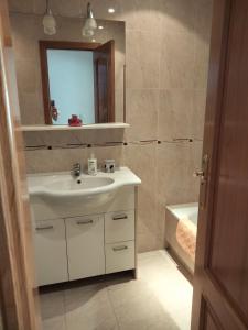 a bathroom with a sink and a mirror and a tub at APARTAMENTO BEATRIZ in A Pobra do Caramiñal