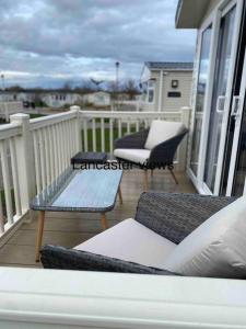 un porche con sillas y una mesa en el balcón en Lancaster Views, Luxury 2022 home with Hot Tub, en Tattershall