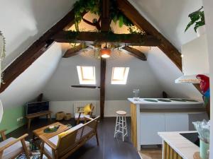 a kitchen and dining room with a ceiling with beams at Sous les tropiques d’Ablis in Ablis