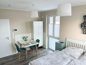 een slaapkamer met een bed en een tafel en stoelen bij Appartement - Wildecker Ferienbutze in Hönebach