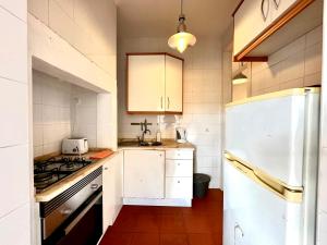 uma cozinha com um frigorífico branco e um lavatório em Alcantara 2 Bedrooms Apartment em Lisboa