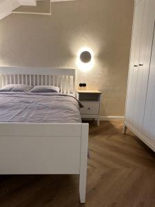 1 dormitorio con cama blanca y mesita de noche blanca en B34 Loft Apartment, en Riga
