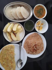 烏代浦的住宿－Madan Mohan Villas (A Haritage Haveli Home Stay)，餐桌,盘子上放着食物和碗
