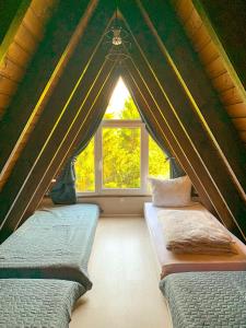 two beds in a room with a window at Ferienhaus Rhön-Auszeit in Bischofsheim an der Rhön