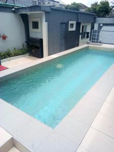 a swimming pool with blue water in front of a building at Primal Msquare Apartment Ikoyi in Lagos