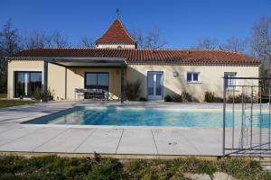 a house with a swimming pool in front of it at Coteaux De Braules in Gindou