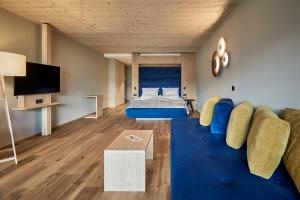 ein Wohnzimmer mit einem Sofa und einem Bett in der Unterkunft Vinumhotel Feldthurnerhof in Feldthurns