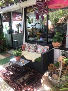 a porch with a couch and a table with plants at Dépendance de 30m² dans maison avec entrée privée in Six-Fours-les-Plages