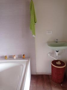 a bathroom with a bath tub and a sink at Hermosa Cabaña Campestre in Pereira