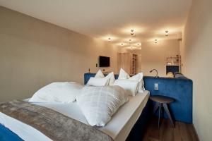 a bedroom with a large bed with white pillows at Vinumhotel Feldthurnerhof in Feldthurns