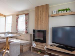 a living room with a large flat screen tv at Caravan Skegness 8 Berth in Skegness