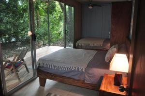 a bedroom with a bed and a sliding glass door at Alegria River Hideaway and Retreats in Cuajiniquil