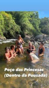 um grupo de mulheres sentadas na água em Pousada Rosa dos Ventos Kchu em Cachoeiras de Macacu
