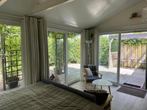 a bedroom with a bed and a sliding glass door at Coast Holiday Appartements in Dirkshorn