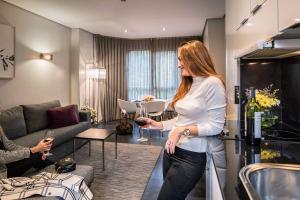 a woman standing in a room holding a glass of wine at Apartosuites Jardines de Sabatini in Madrid