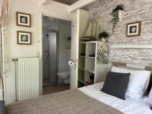 a bedroom with a bed and a bathroom at Coast Holiday Appartements in Dirkshorn