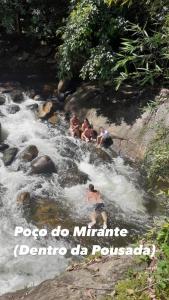 a group of people swimming in a river at Pousada Rosa dos Ventos Kchu in Cachoeiras de Macacu